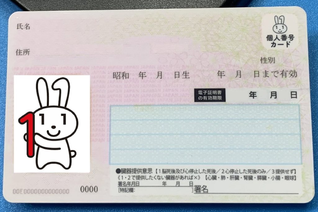 ICカードリーダーに置かれた、個人情報の入っていないマイナンバーカードの見本