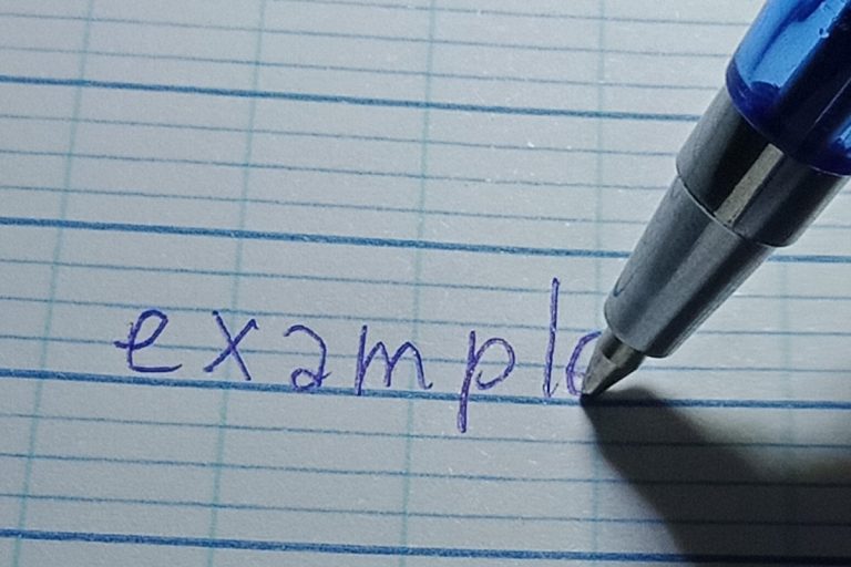 罫線入りの紙にボールペンで「example」と書いているところ
