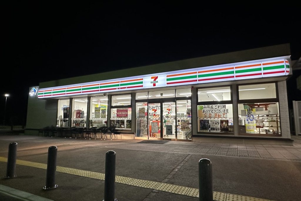 夜のパーキングエリアにあるセブン-イレブンの店舗外観
