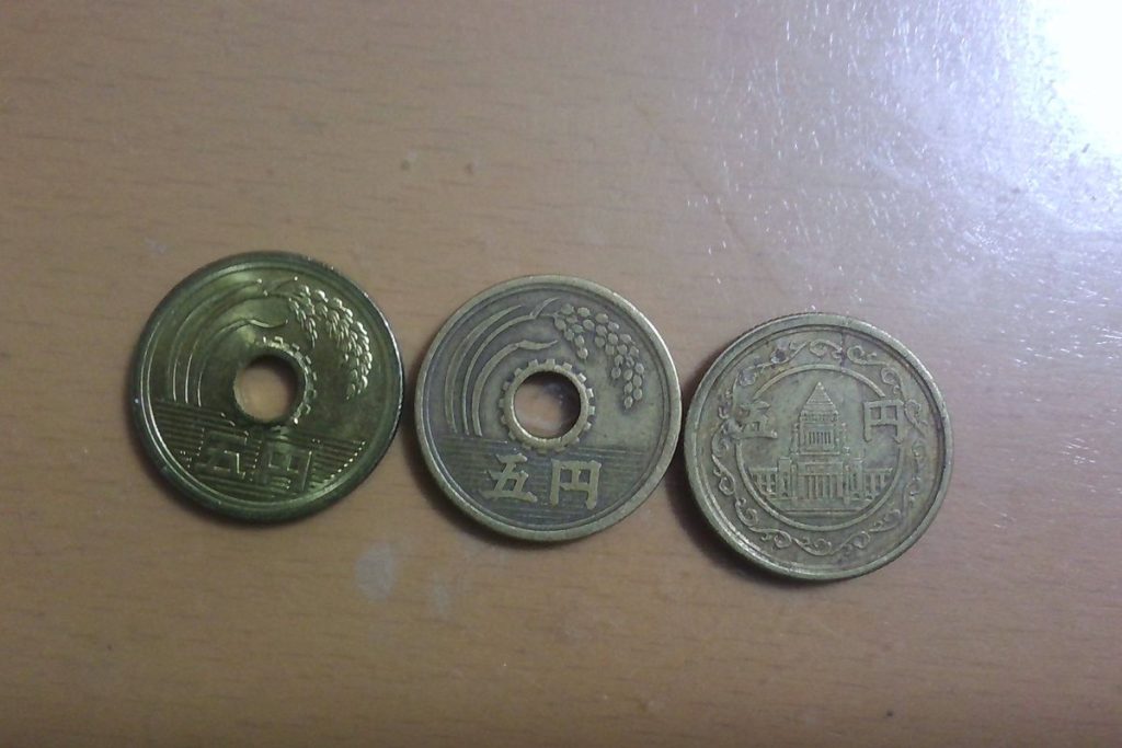 デザインの異なる5円硬貨が3枚並んでいる