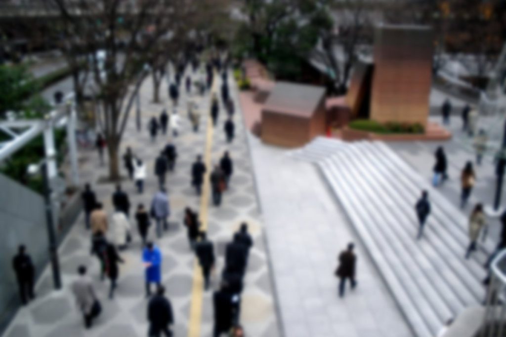 朝の通勤時間に西新宿の高層ビル街を歩く会社員たち