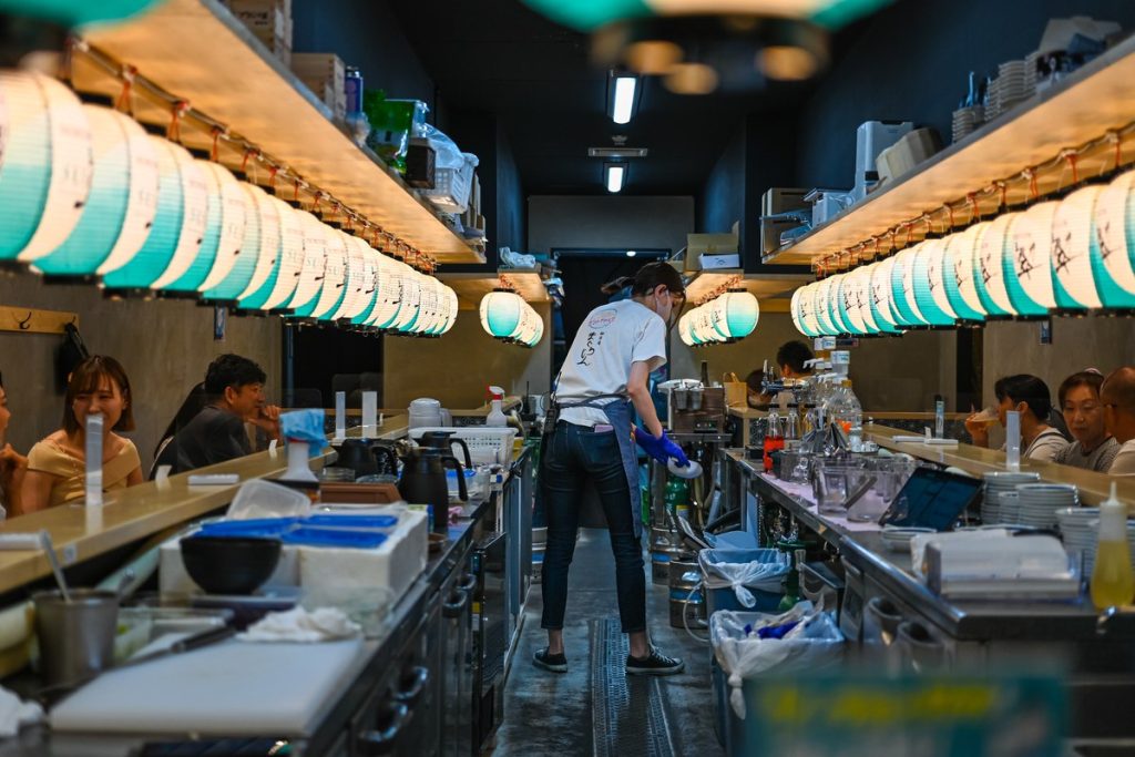 大阪・天満の居酒屋のカウンターで働くスタッフ